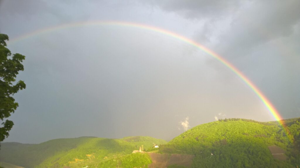 Breathtaking Rainbow Over Lush Green Mountains PC Wallpaper