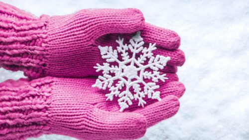 Hands in Pink Knitted Mittens Holding a Snowflake Desktop Wallpaper
