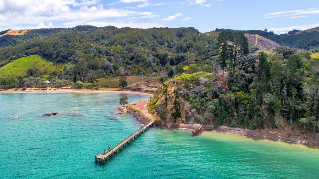 Stunning Aerial View of Coastal Pier and Lush New Zealand Landscape PC Wallpaper