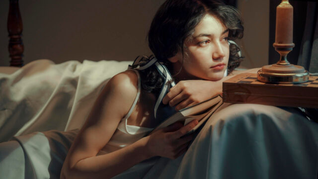 Pensive Young Woman Reading a Book in Soft Sunset Light 4K Wallpaper