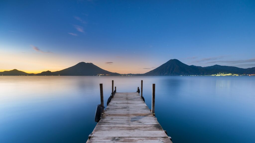 Serene Lake Atitlan Pier with Volcanic Mountain View PC Wallpaper