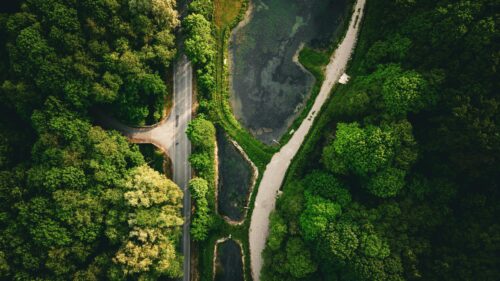 Aerial View of Forest Road and Serene Lake Nature PC Wallpaper