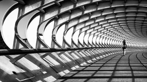 Woman Walking Through Modern Architectural Tunnel Black and White PC Wallpaper