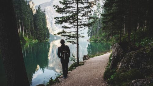 Woman Hiker Standing by Serene Alpine Lake Mountains PC Wallpaper