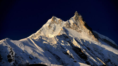 Majestic Snow Capped Mountain Peak Under Deep Blue Sky 4K Wallpaper