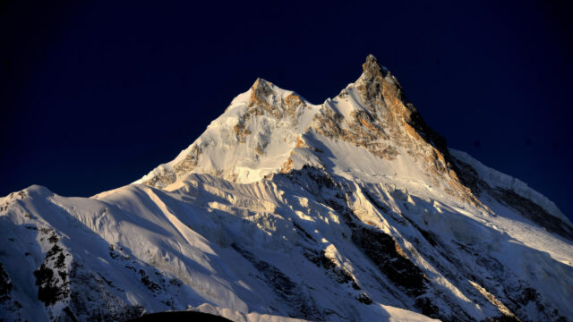 Majestic Snow Capped Mountain Peak Under Deep Blue Sky 4K Wallpaper