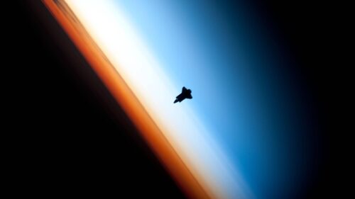 Space Shuttle Silhouette Against Earth Horizon Atmospheric Glow 4K Wallpaper