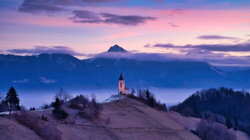 Stunning Church on Hillside at Sunset over Slovenian Alps 4K Wallpaper