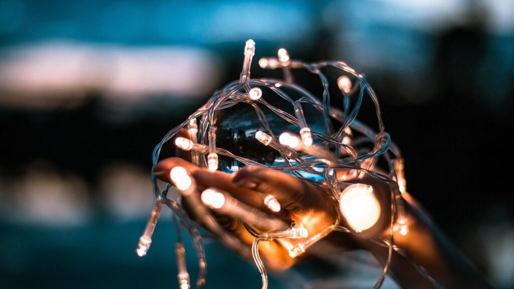 Close up of Hands Holding Glowing LED Fairy Lights in Crystal Sphere PC Wallpaper