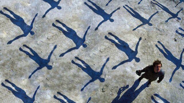 Surreal Artistic Man Standing Among Human Shadows Concept 4K Wallpaper