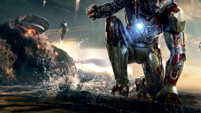 Iron Man Kneeling Amidst Explosive Battle Desktop Wallpaper