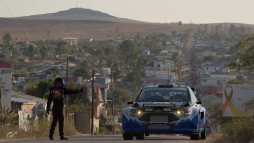 Rally Car Driver Giving Thumbs Up Desert Town Desktop Wallpaper