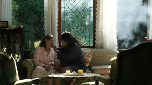 Caring Interaction in a Sunlit Living Room Desktop Wallpaper
