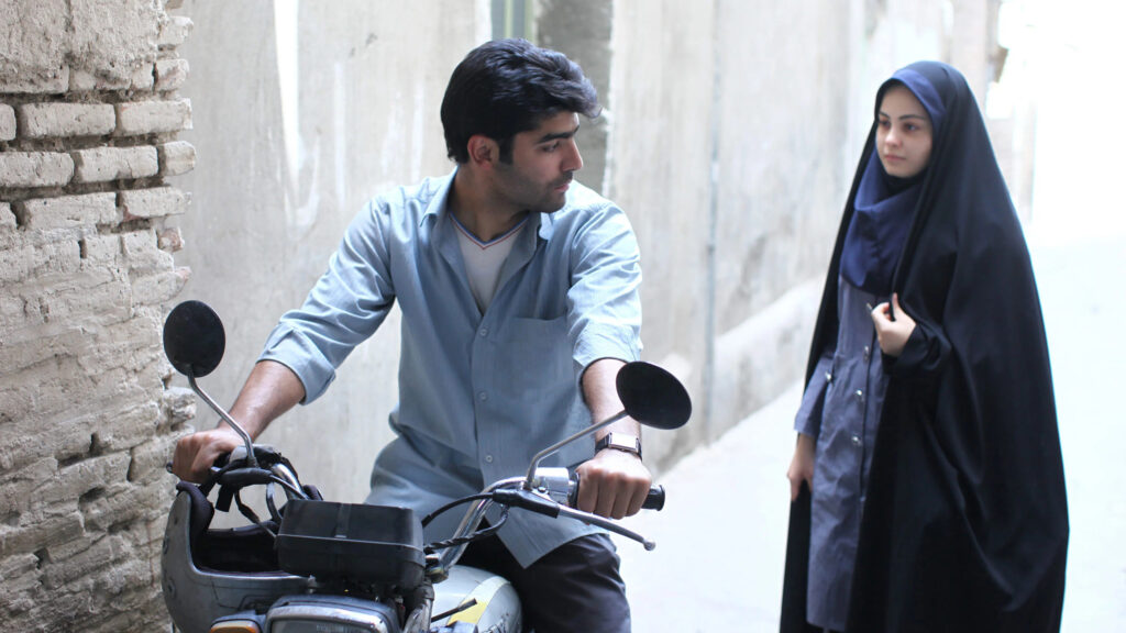 Young Man on Motorcycle and Woman in Chador 4K Desktop Wallpaper