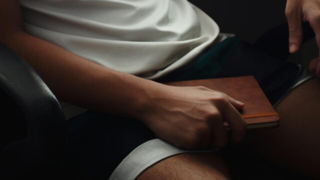 A Person Holding a Leather Journal Minimalist Professional Desk 4K Wallpaper