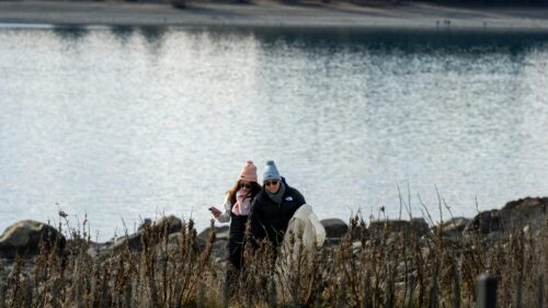 Couple Walking Near Sparkling Lake Winter Scene 4K Wallpaper