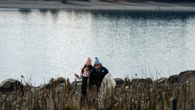 Couple Walking Near Sparkling Lake Winter Scene 4K Wallpaper