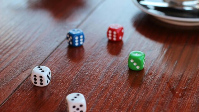 Colorful Dice Scattered on Rustic Wooden Table 4K Desktop Wallpaper