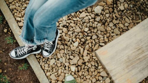 Casual Style Person Wearing Converse Sneakers on Gravel Path Desktop Wallpaper