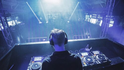 DJ Performing Live in Front of a Crowded Nightclub Stage Desktop Wallpaper
