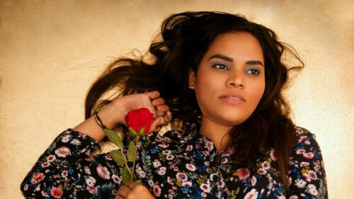 Beautiful Woman Holding Red Rose against Golden Backdrop 4K Wallpaper