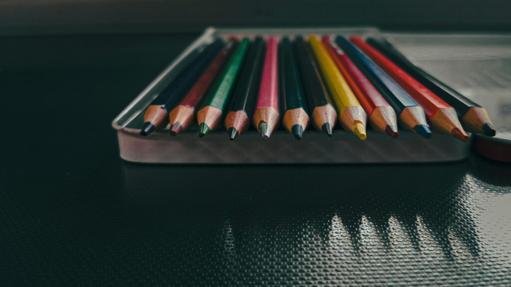 Macro Close-up of Vibrant Colored Pencils in Metal Tin Case Desktop Wallpaper