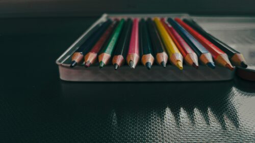Macro Close-up of Vibrant Colored Pencils in Metal Tin Case Desktop Wallpaper