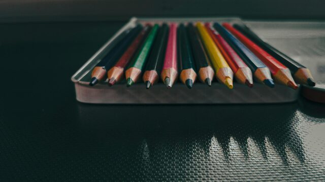 Macro Close-up of Vibrant Colored Pencils in Metal Tin Case Desktop Wallpaper
