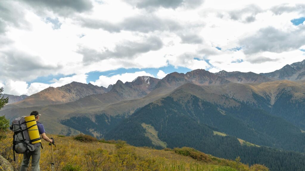 Hiker Trekking Through Majestic Mountain Ranges Desktop Wallpaper