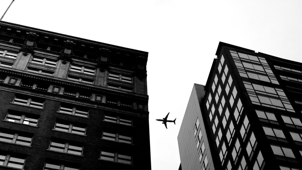 Airplane Flying Between Two Skyscrapers Urban Cityscape 4K Wallpaper