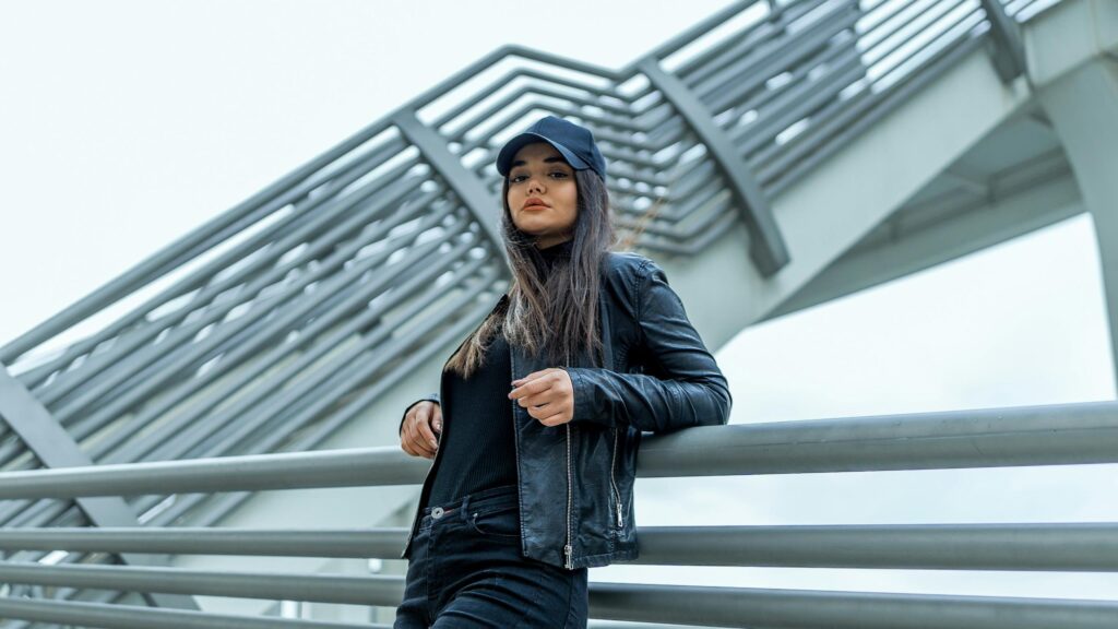 Stylish Woman in Leather Jacket Leaning on Bridge 4K Desktop Wallpaper