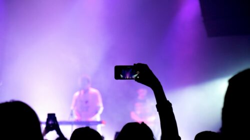 Concert Audience Filming Performance Purple Stage Lights 4K Wallpaper