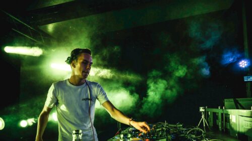 DJ Performing Live on Stage with Green Smoke Effects 4K Wallpaper