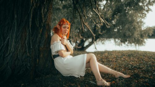 Enchanting Redheaded Forest Elf Sitting by a Tree Desktop Wallpaper