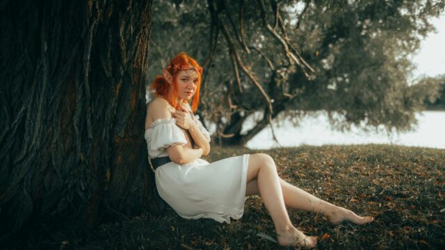 Enchanting Redheaded Forest Elf Sitting by a Tree Desktop Wallpaper