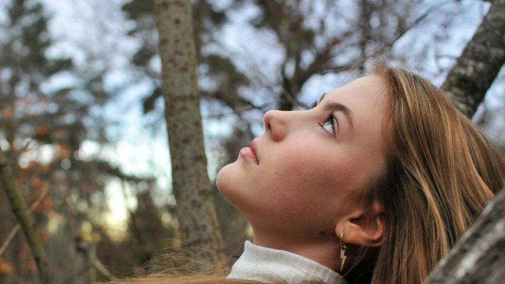 Serene Young Woman Looking Up in Nature 4K Desktop Wallpaper