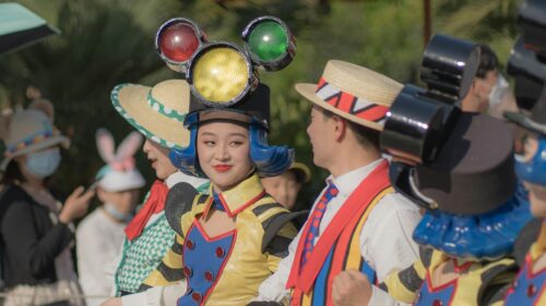 Vibrant Disney Performers in Colorful Parade Costumes Desktop Wallpaper