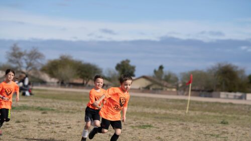 Energetic Children Playing Soccer Outside 4K Desktop Wallpaper