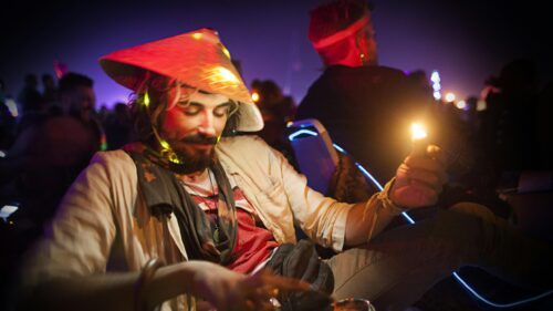 Man in Neon Asian Hat with Lighter at Music Festival Desktop Wallpaper