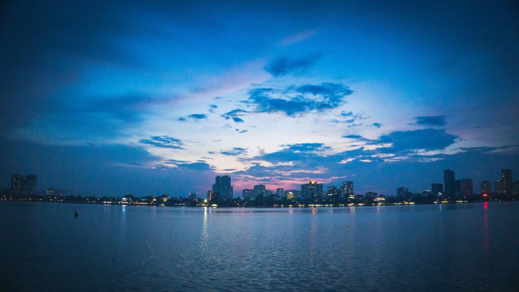 Stunning City Skyline Over Calm Lake at Twilight 4K Desktop Wallpaper