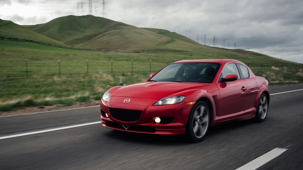 Red Mazda RX-8 Sports Car Driving on Mountain Road Desktop Wallpaper
