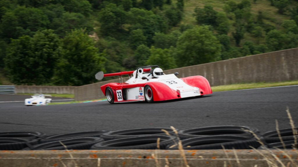 Red and White Race Car Speeding on Track 4K Desktop Wallpaper