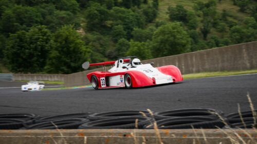 Red and White Race Car Speeding on Track 4K Desktop Wallpaper