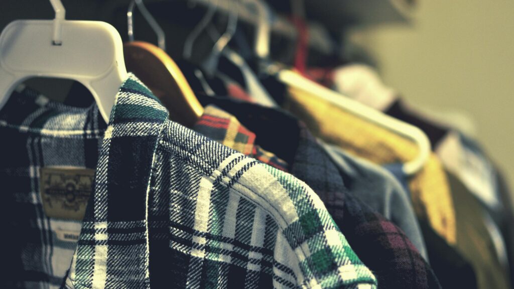 Cozy Flannel Plaid Shirts Hanging in a Closet Desktop Wallpaper