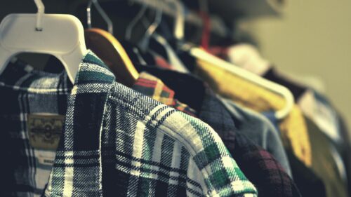 Cozy Flannel Plaid Shirts Hanging in a Closet Desktop Wallpaper