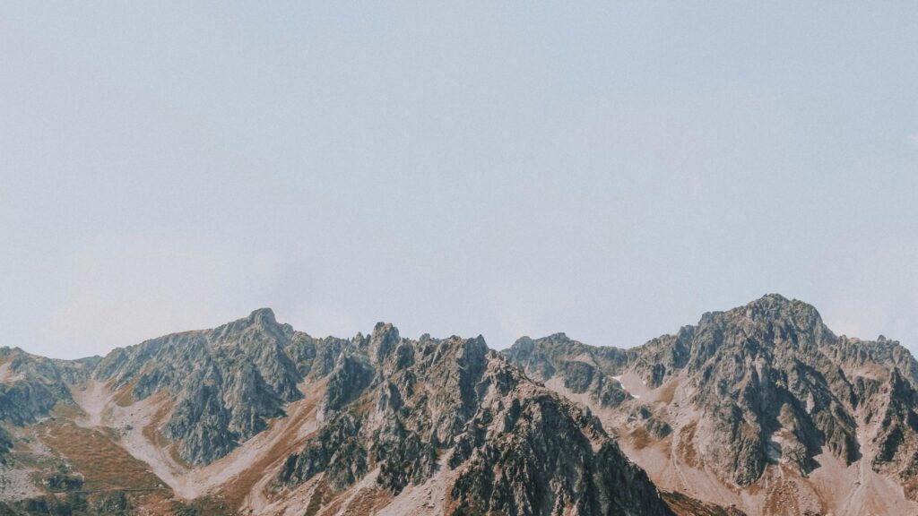 Majestic Rugged Mountain Peaks Under Clear Sky Desktop Wallpaper