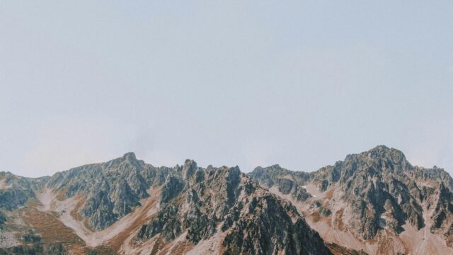 Majestic Rugged Mountain Peaks Under Clear Sky Desktop Wallpaper