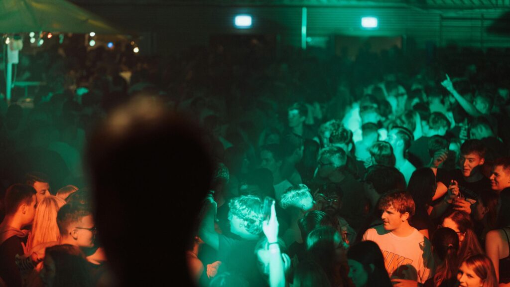 Crowd Dancing Under Green Neon Lights Nightclub 4K Wallpaper