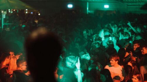 Crowd Dancing Under Green Neon Lights Nightclub 4K Wallpaper