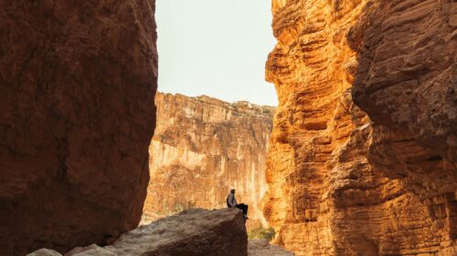 Lone Hiker Sitting on Canyon Rock 4K Wallpaper